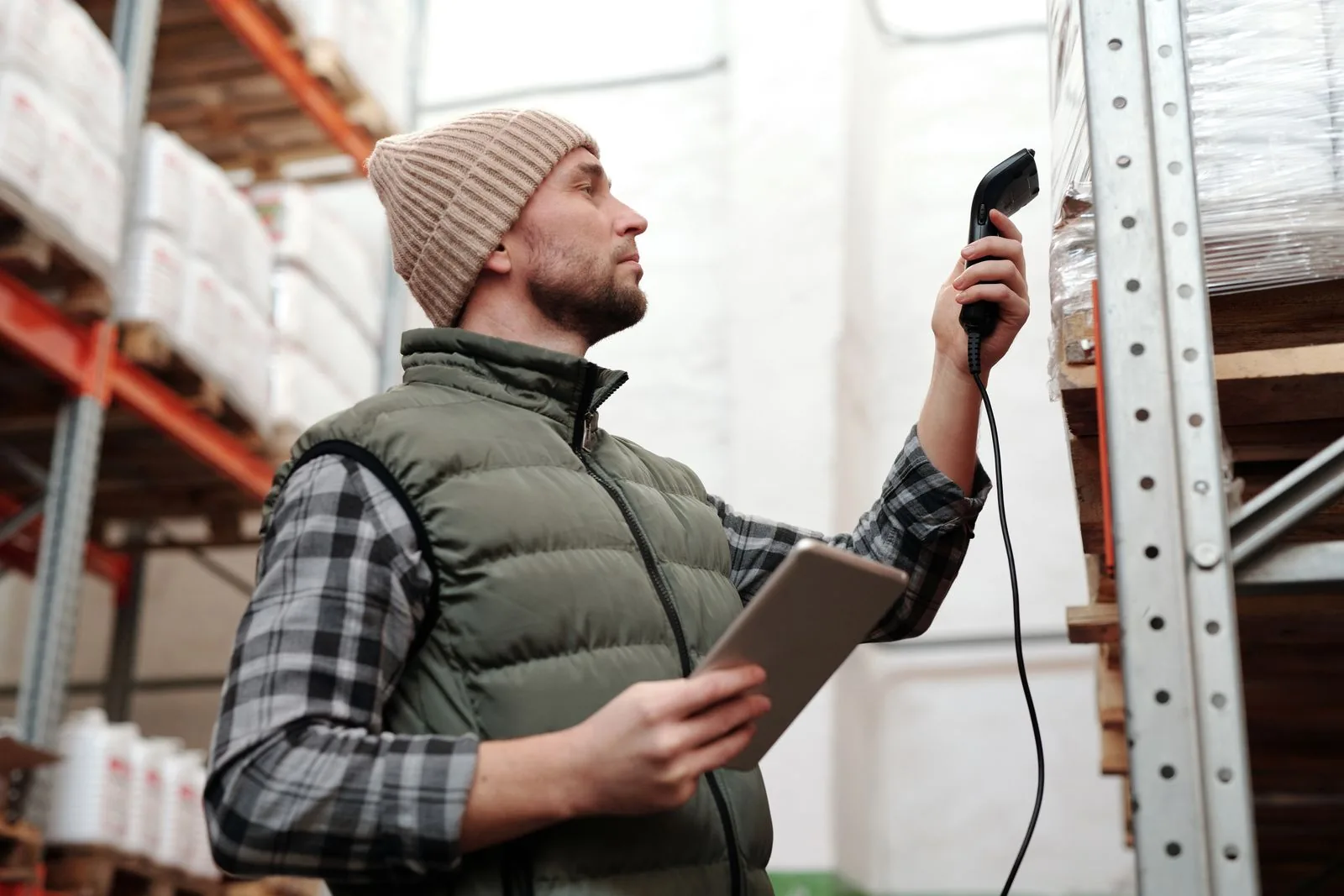 Warehouse operator scanning stock with a handheld device and tablet